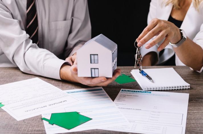 Real estate agent holding a miniature house
